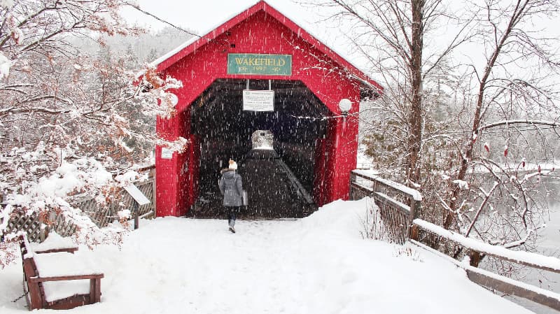 woman at the entrance of a covered bridge